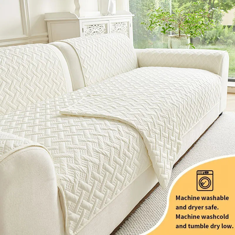 A white quilted anti-slip sofa cushion lying on a light gray sofa.
