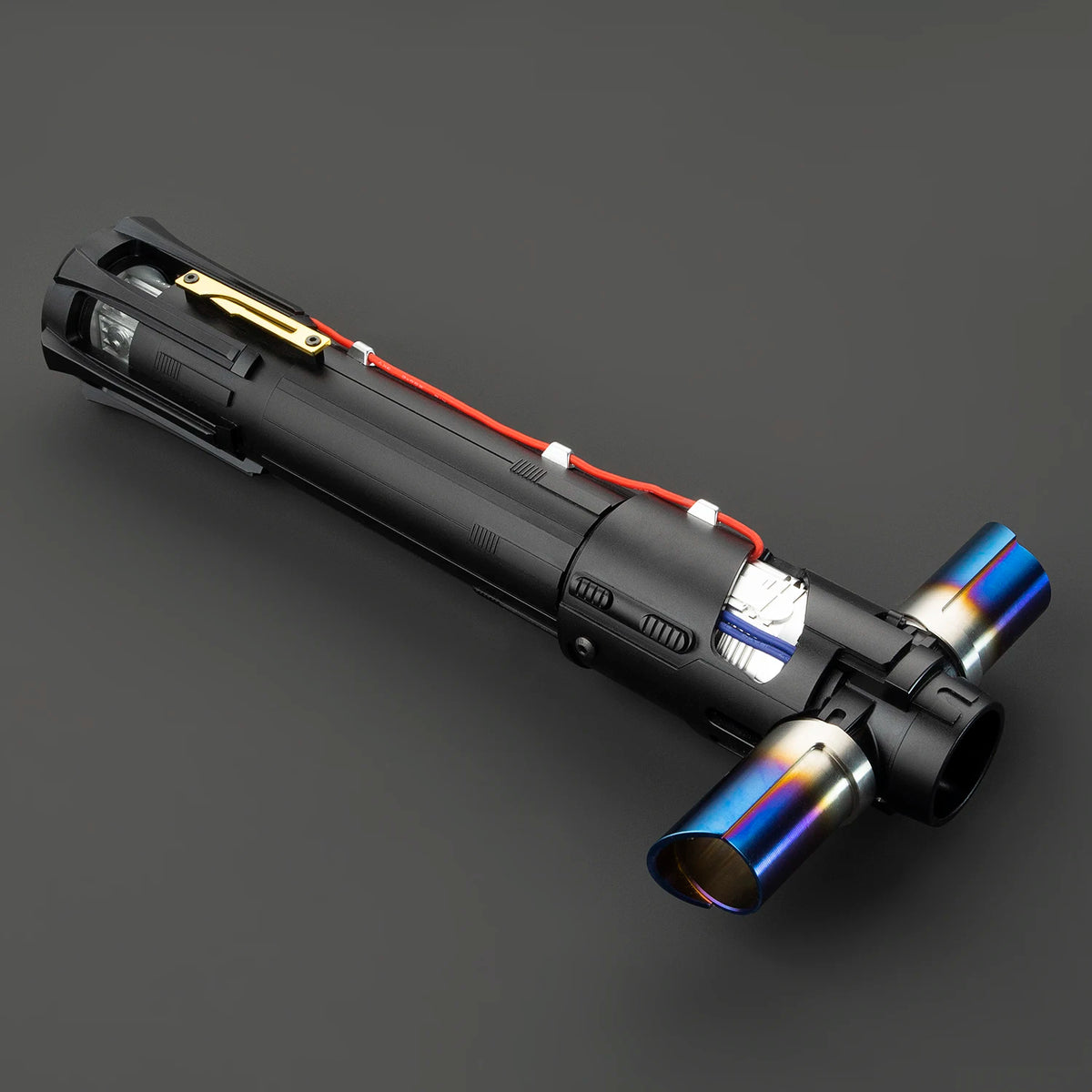 A black metal lightsaber with a gold hilt and red wiring is shown against a dark gray background.