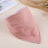 A soft pink cotton baby bib with a textured surface is shown on a light background.