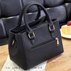 A black vintage PU leather tassel shoulder bag with a crossbody strap resting on a wooden surface.