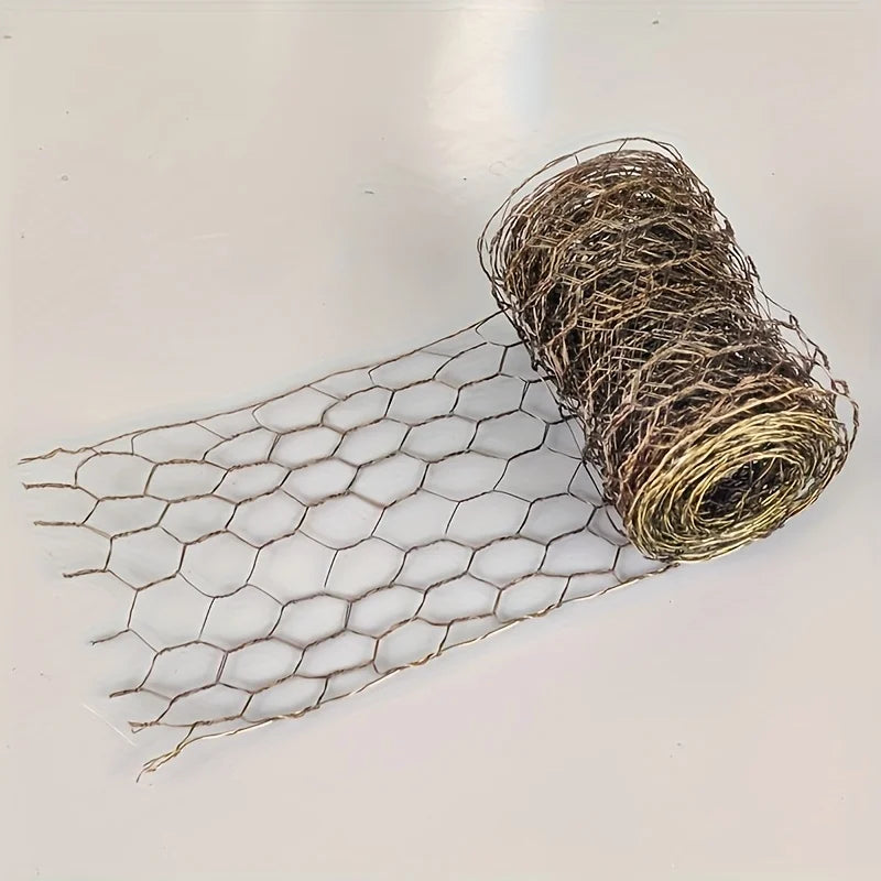 A roll of thin, wire-like netting with a hexagonal mesh pattern laid out next to the coiled material.