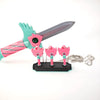 A set of four pink and teal dagger key necklaces displayed on a black base.