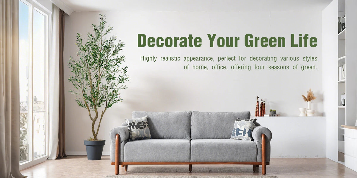 A gray sofa in a bright room with a large potted olive tree and a wall sign encouraging decorating a green life.