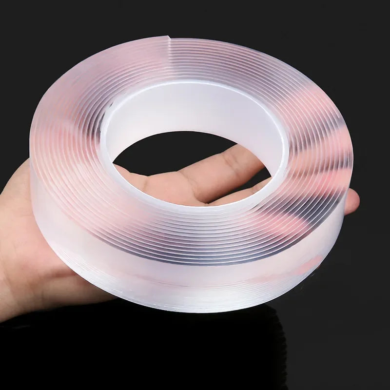 Une main tient un rouleau de ruban adhésif nano transparent et translucide double face.