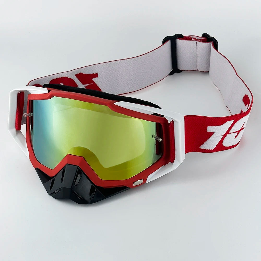 Red and white motorcycle goggles with a black strap resting on a white surface.