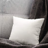 A white soft comfort cushion resting on a dark gray textured fabric.
