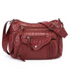 A maroon leather tote bag with a flap closure and adjustable strap is shown against a white background.