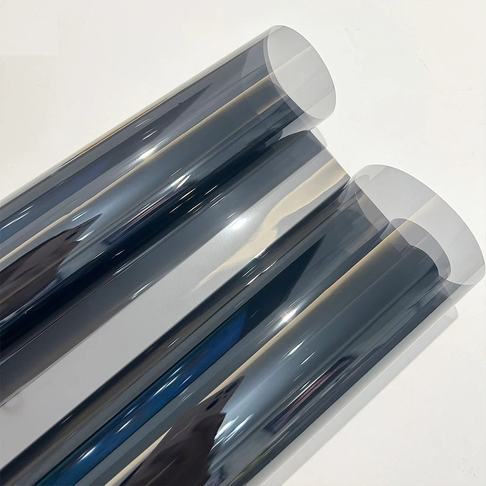 Close-up view of a roll of ceramic car window tint film showing various shades of blue and gray.