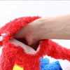 A hand is holding a bright red, fluffy Elmo hand puppet toy.