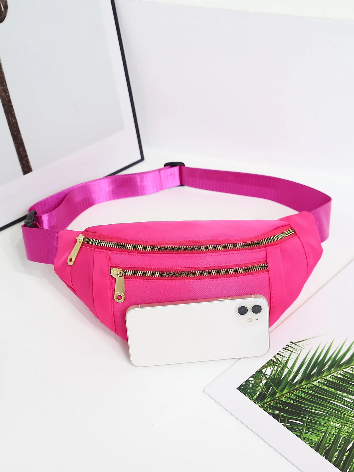 Helle pinke Mehrfach-Sport-Geldertasche mit Reißverschluss, auf einer weißen Oberfläche.