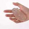 A hand holds a translucent, clear stress putty for massage or therapeutic use.