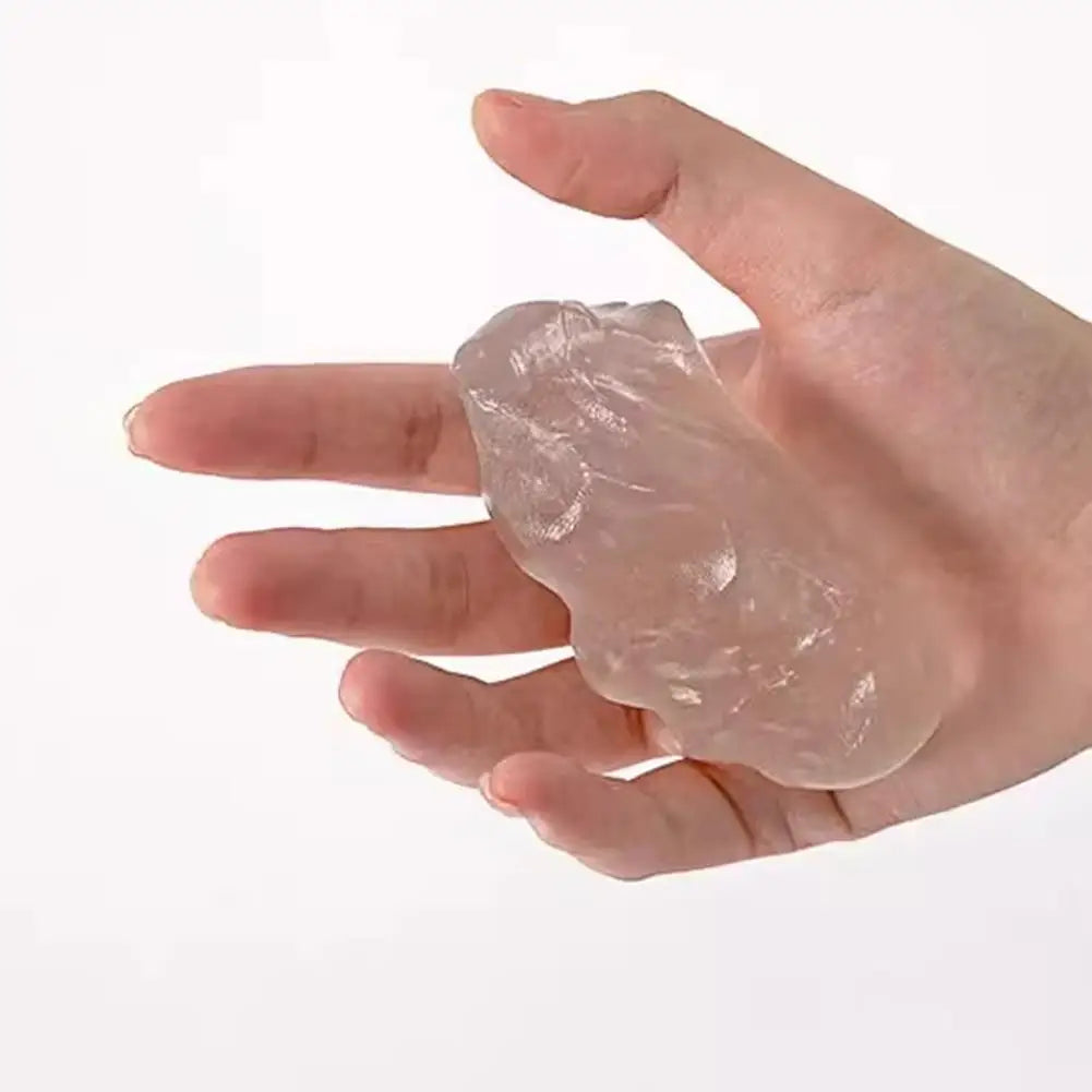 A hand holds a translucent, clear stress putty for massage or therapeutic use.