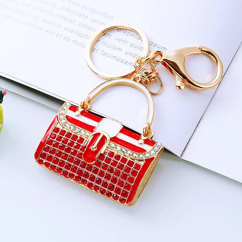 A crystal rhinestone handbag keychain with a red and white design is shown against a white background.
