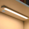 A long, rectangular LED light fixture with a motion sensor is mounted on a wall in a room.