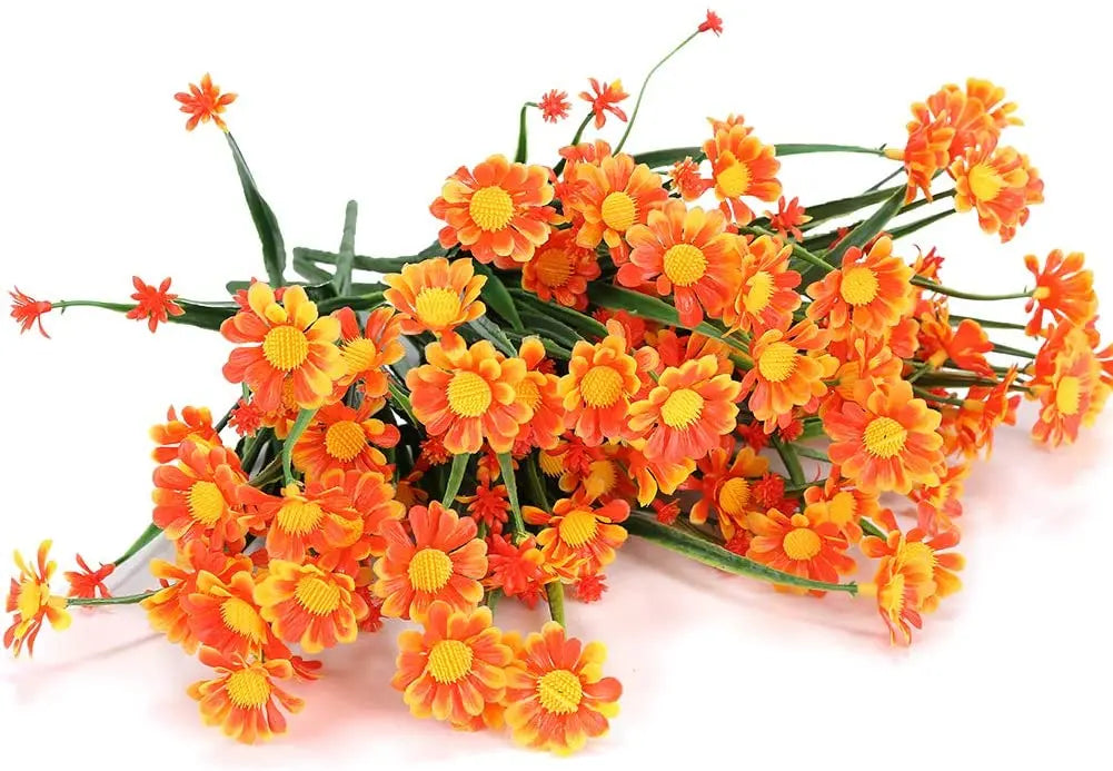 Ein Strauß leuchtend orangefarbener und gelber künstlicher Margeriten für Dekoration drinnen und draußen.