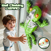 A smiling boy is holding a green wall climbing lizard toy with LED eyes in front of a window.