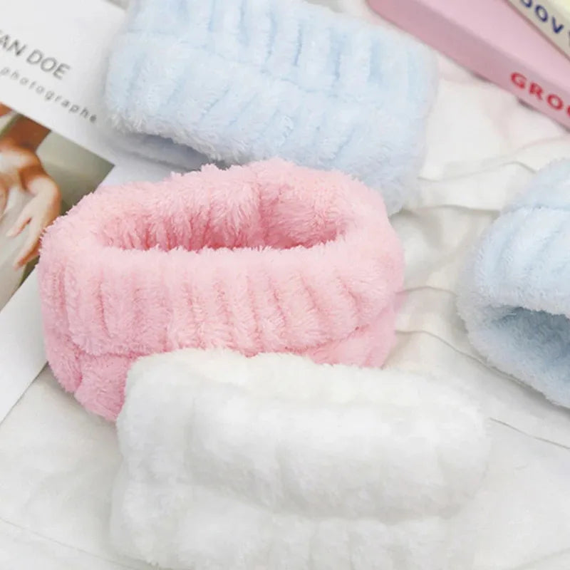 A collection of pink, blue, and white absorbent microfiber wrist washing bands or cuffs.