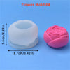 A pink silicone flower mold with a center depression is shown next to its white counterpart.