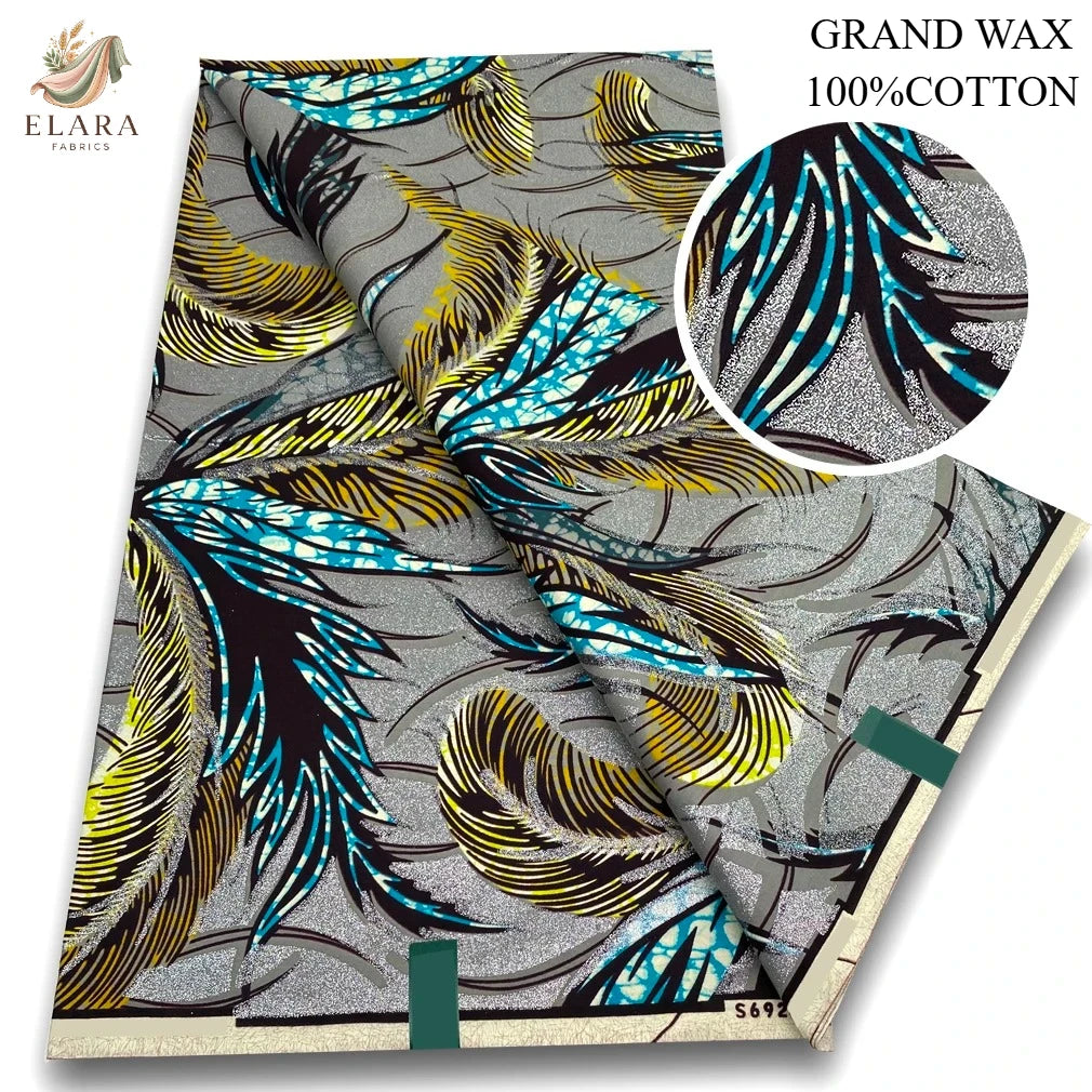 Gray fabric with a pattern of black, yellow, and bright blue feathers, sold as Grand Wax 100% cotton.