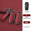A red car key case cover with a black button remote and a leather bracelet clasp shown on a maroon background.