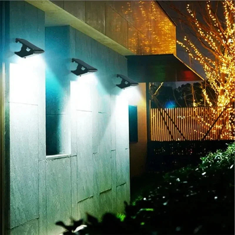 A modern outdoor wall light fixture illuminates a textured wall and surrounding foliage at night.