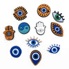 A collection of nine colorful PVC pins featuring various eye and hand symbols for decoration.