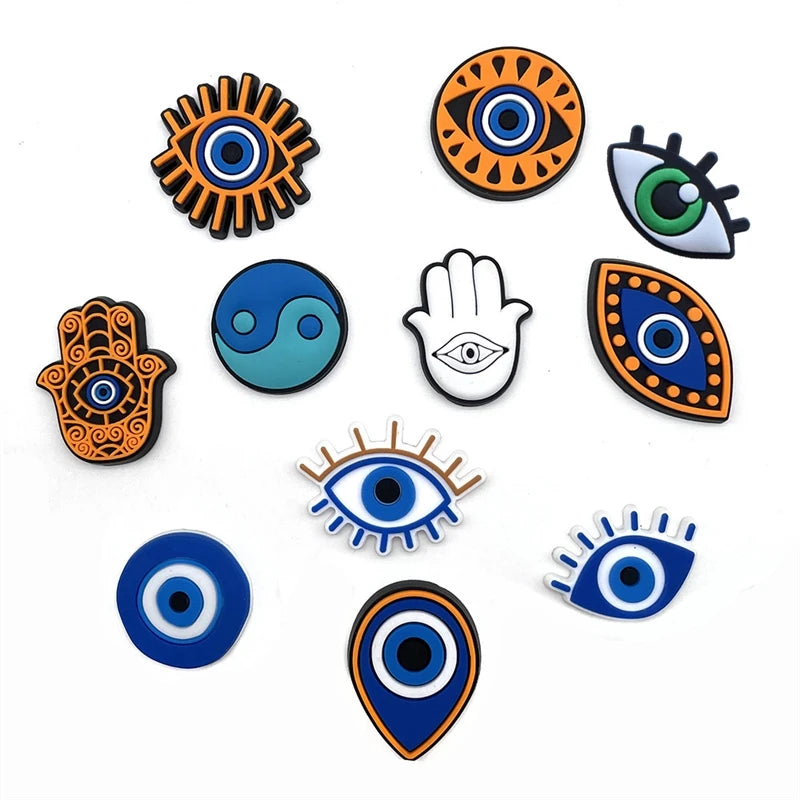 A collection of nine colorful PVC pins featuring various eye and hand symbols for decoration.