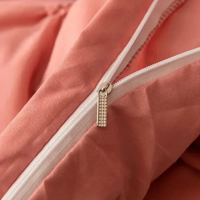 Close-up of a pink pinch pleated duvet cover with a silver zipper pull detail.