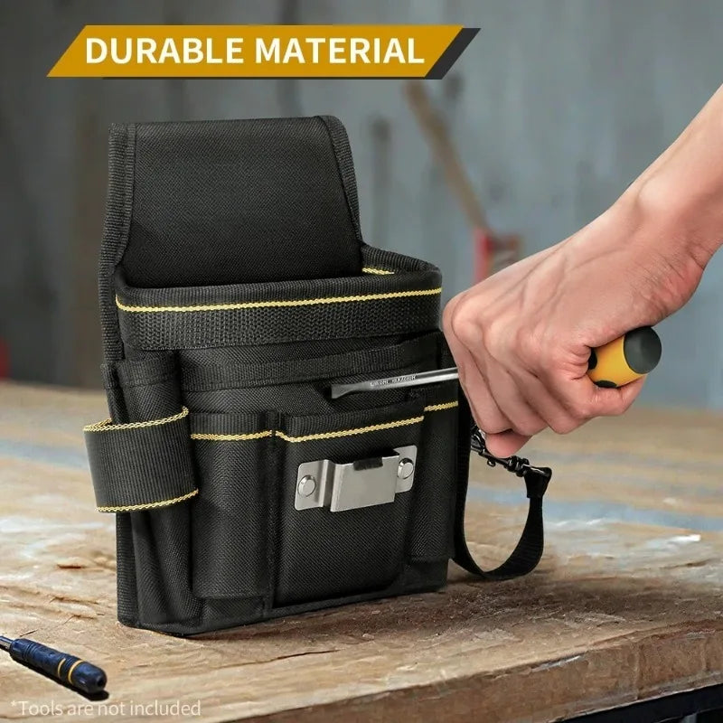 A black durable tool bag with a silver clasp and yellow stitching is held by a hand on a wooden surface.