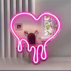 A neon sign shaped like a heart dripping with pink light, displayed on a shelf.