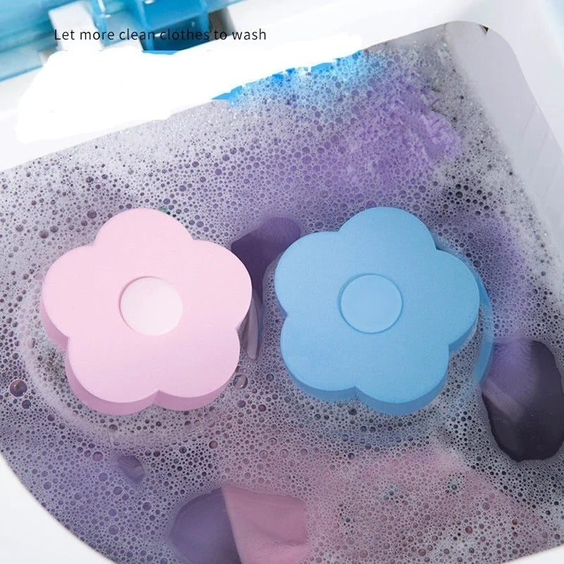 Pink and blue flower shaped lint and hair catcher filter bags floating in soapy water inside a washing machine drum