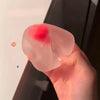 Eine Hand presst ein rosa, durchsichtiges Stressabbau-Spielzeug in Form einer Erdbeermochi.