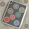 A gray phone case features several colorful mandala and graffiti stickers in various sizes and patterns.