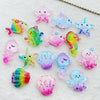 A collection of colorful, iridescent resin charms shaped like starfish and sea creatures for crafting.