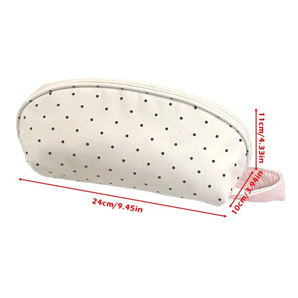 A cream-colored shell-shaped pencil case with polka dots and multi-compartment storage.