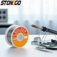 A spool of solder core wire is shown next to a soldering iron and tools on a white surface.