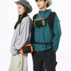 A young man and woman standing side by side, wearing outdoor-inspired clothing and a tactical waist bag.
