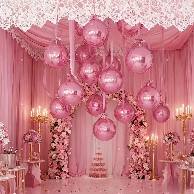 A pink draped backdrop featuring metallic pink round foil balloons and floral arrangements for an event.