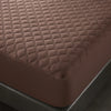 A close-up view of a brown quilted mattress protector with a deep pocket design.