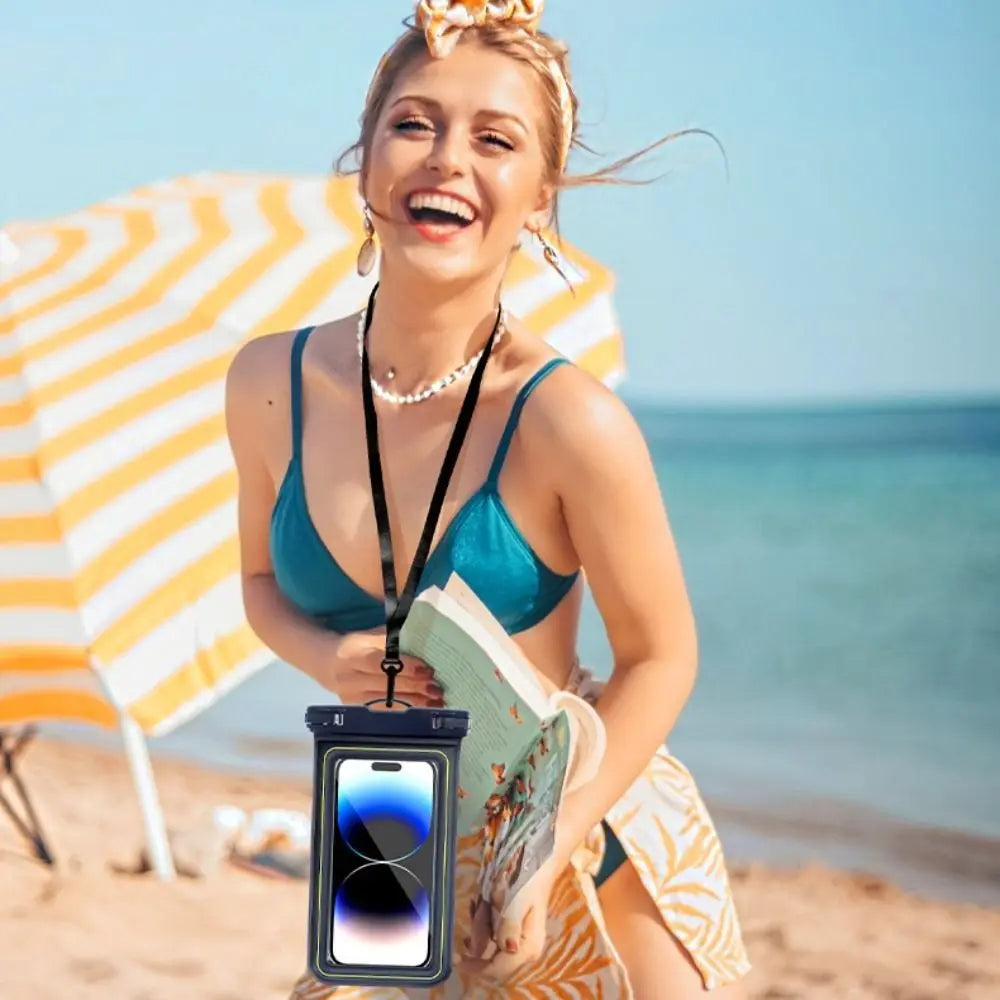A smiling woman wearing a turquoise bikini and a crown is holding a waterproof floating phone case on a beach.