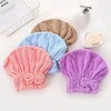 A set of three microfiber hair drying towels in shades of beige, light blue, and purple with bow-knot head wraps.