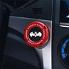 A close-up of a red and black rotating protective cover for a car ignition start button.