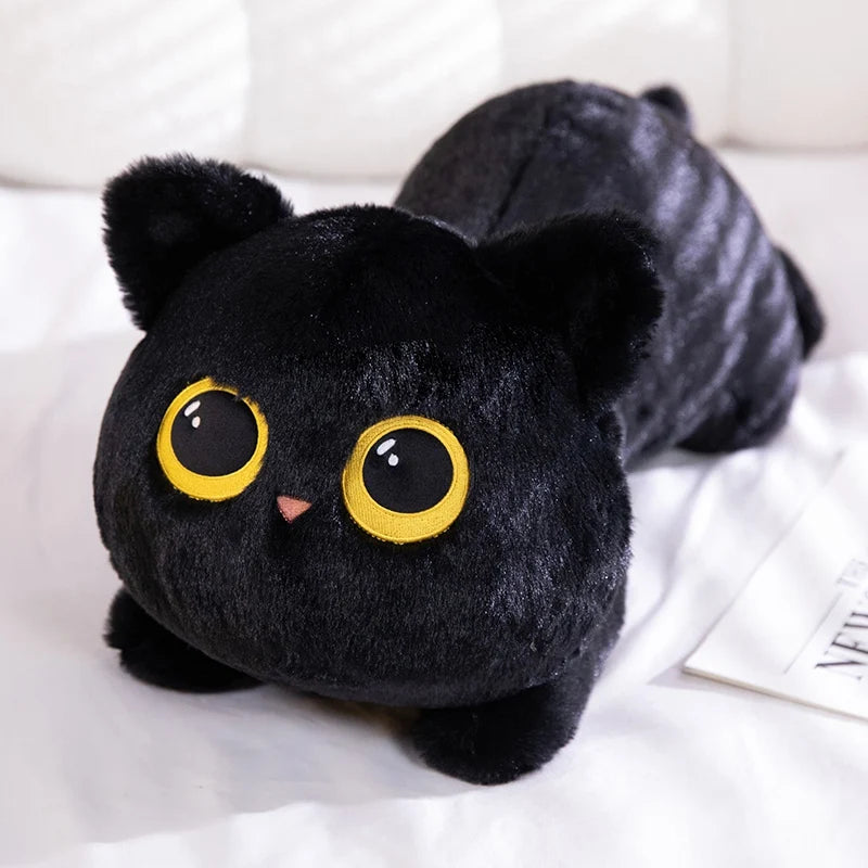 A black plush cat toy with large yellow eyes is resting on a white surface.