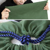A person holds a dark green canvas laundry bag with a blue drawstring closure.