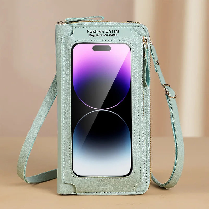 A light mint green hands-free crossbody phone bag with a clear display showing a purple gradient and a silver-tinted screen.