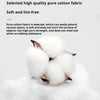 A close-up of four fluffy white cotton towels resting on a light surface.