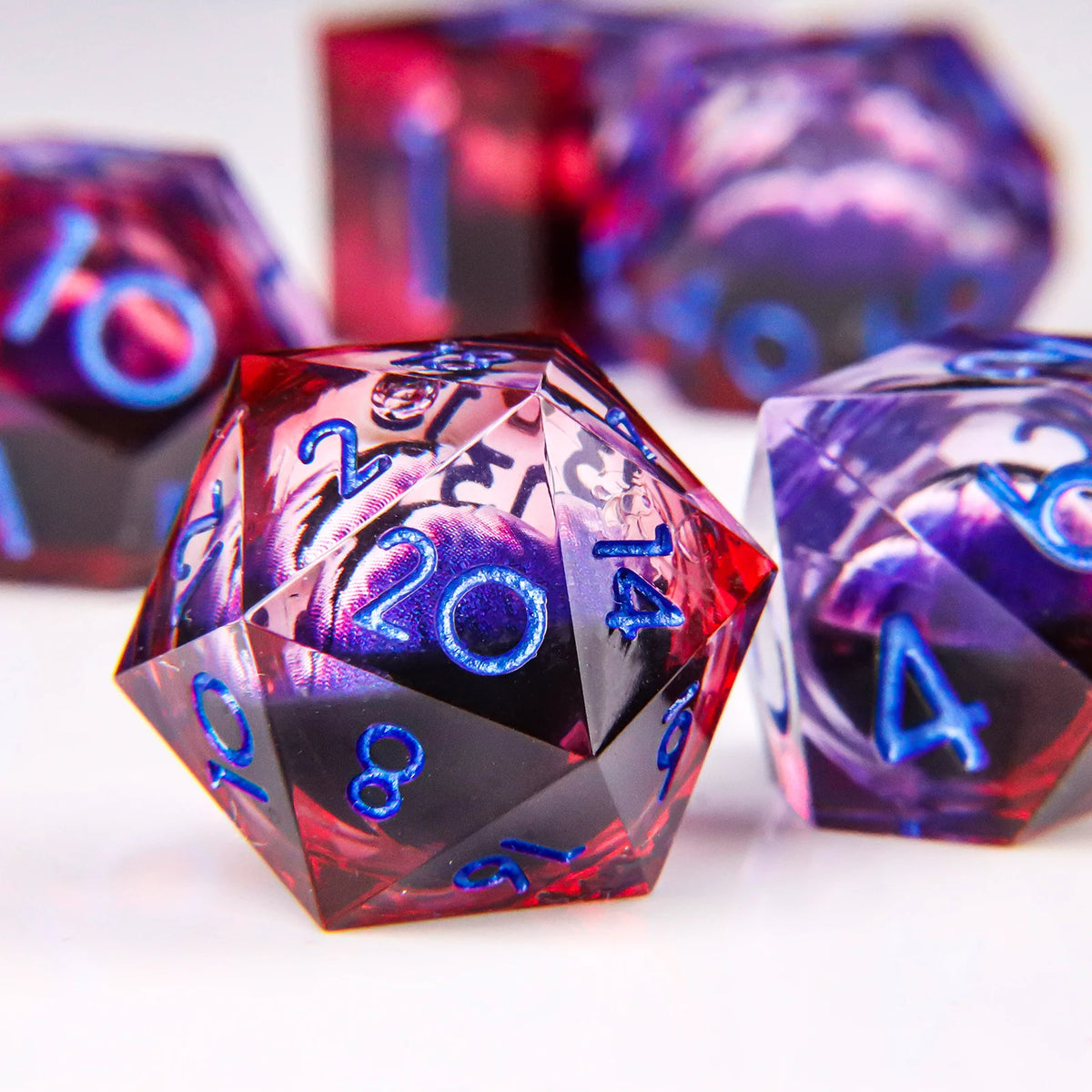 A close-up of a translucent red resin die with a dragon eye design, surrounded by other colored dice.