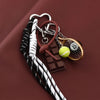 A metal keychain featuring an 8-ball and a chocolate bar charm on a dark brown background.