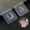Two clear double-sided adhesive wall hooks are shown, with a close-up of one being held by a hand.
