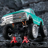 A teal RC crawler vehicle with a chrome grille is shown with a red mini jack stand and tool set.